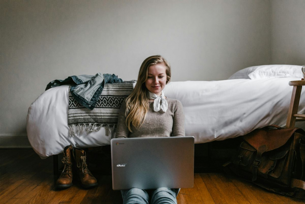 Woman working on laptop in bedroom