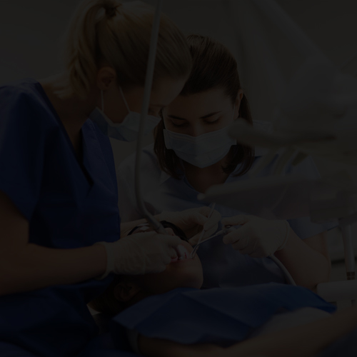 dental assistant working with patient in dentist’s office